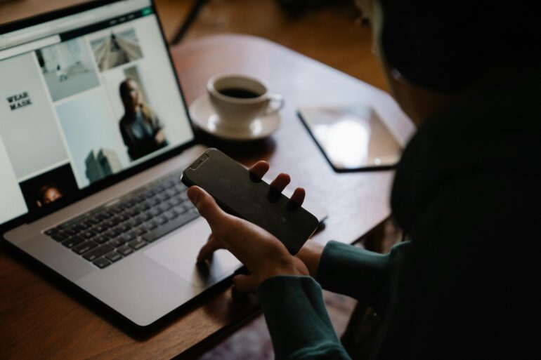 Woman working on laptop with cellphone on hand. Marketingbyneffy. MBN. Spanish SEO